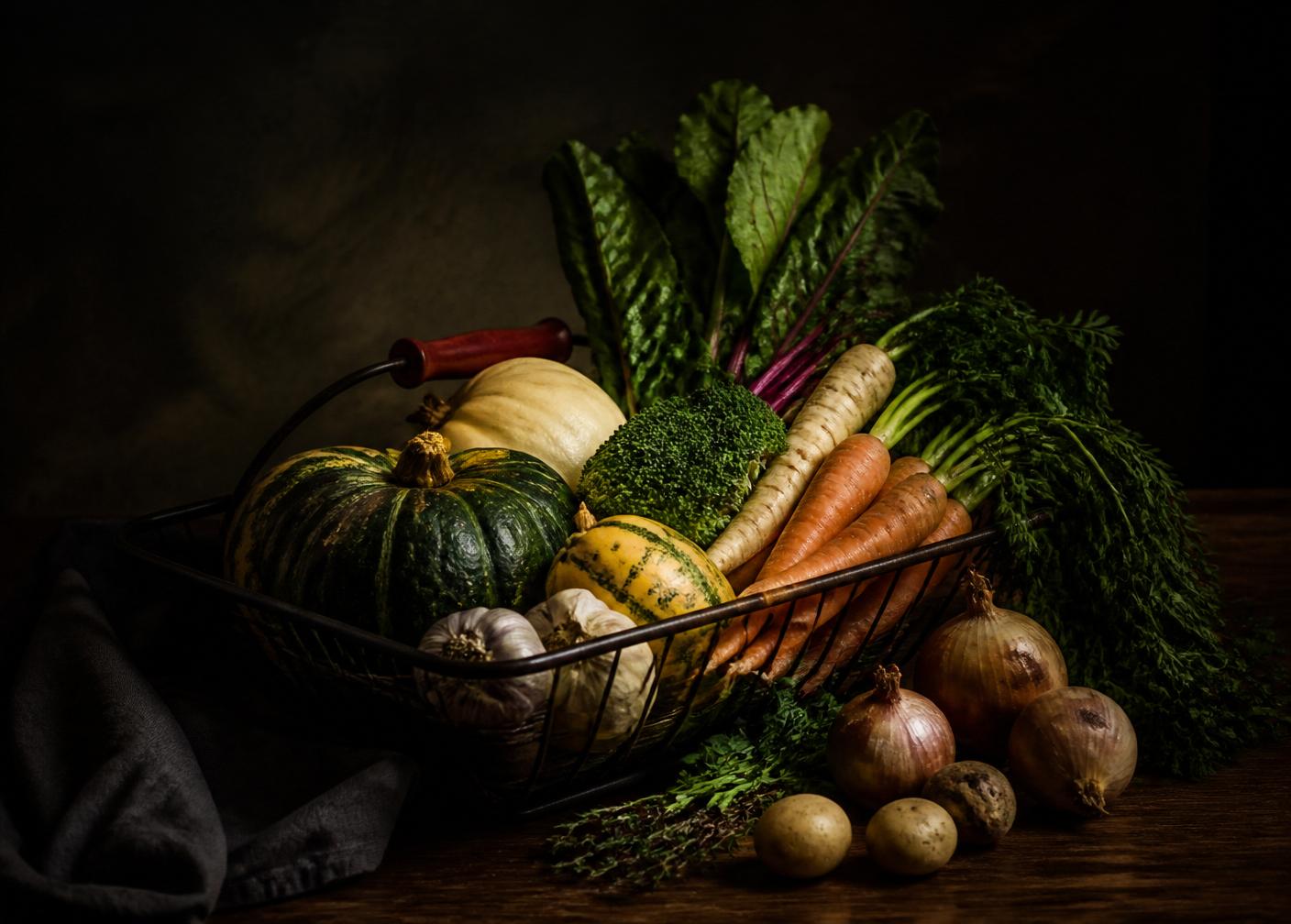 A basket of seasonal produce photographed in warm, low light
